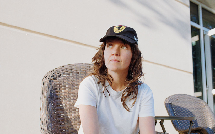 Courtney sitting in a chair, looking away.