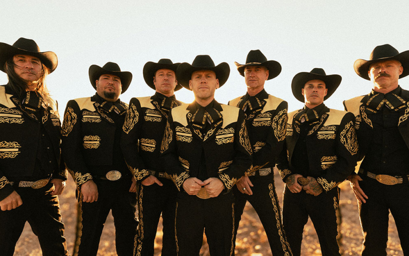 Men outdoors with hats on posing for a photo